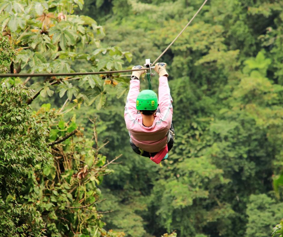 Guest ziplining above the Manuel Antonio rainforest canopy