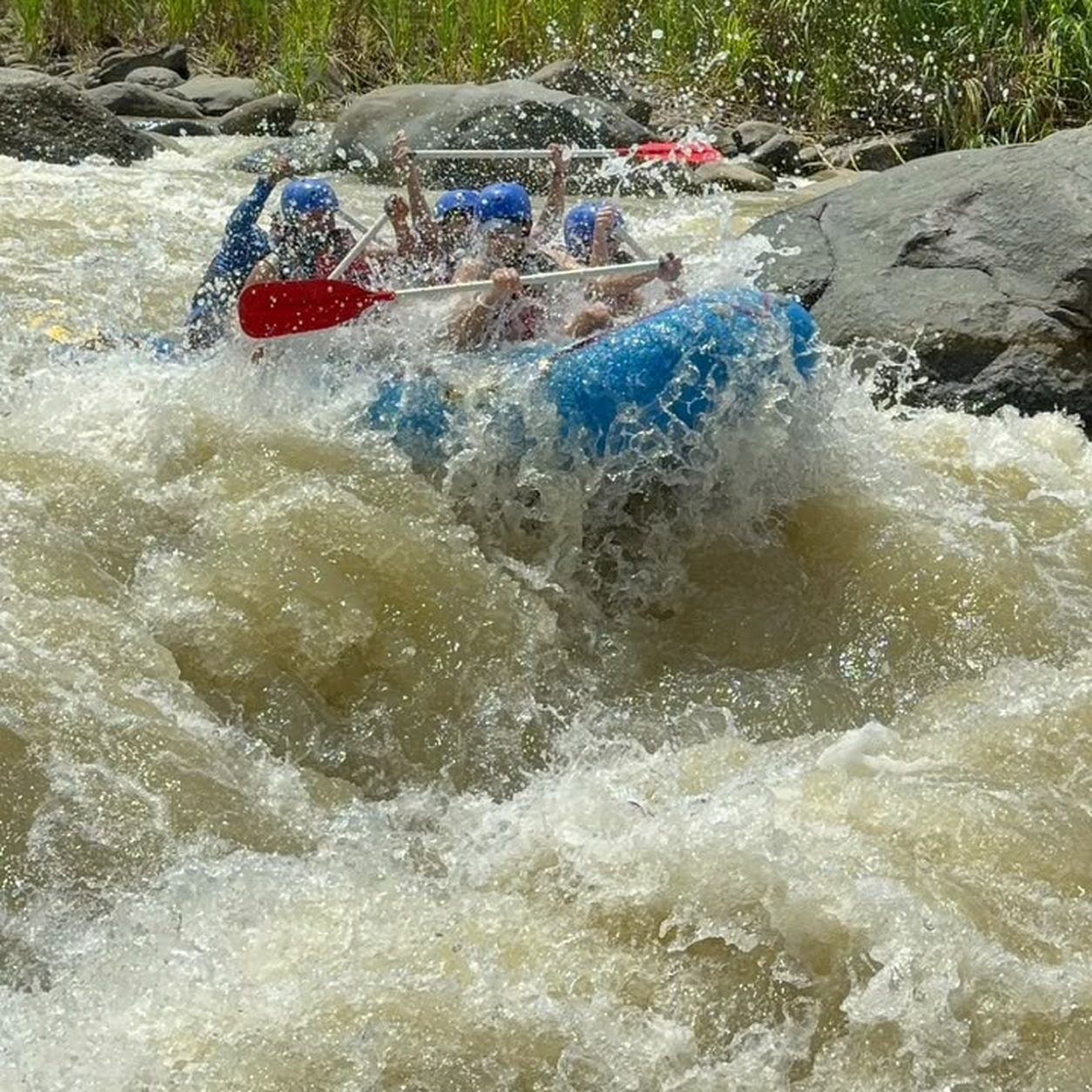 Rafters cheering while running whitewater rapids near Manuel Antonio